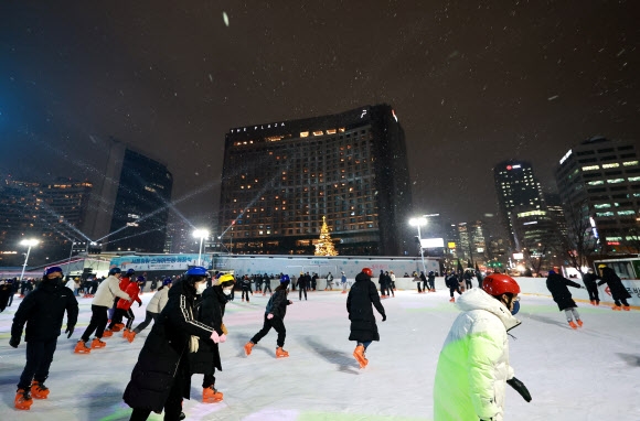 지난 21일 3년 만에 개장한 서울광장 스케이트장에서 시민들이 스케이트를 타고 있다. 연합뉴스 