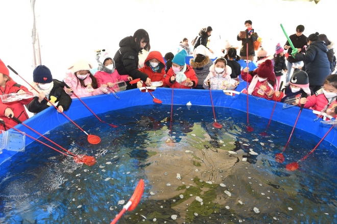 2019년 서울 노원구 ‘중랑천 노원 눈썰매장’에 마련된 빙어 체험장에서 아이들이 빙어를 잡고 있다. 노원구 제공 
