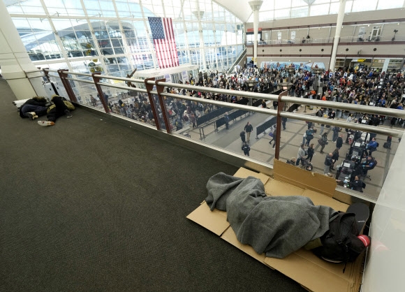 23일(현지시간) 미국 콜로라도주 덴버국제공항에서 폭설에 발이 묶은 여행객들이 공항 바닥에서 잠을 청하고 있다. AP