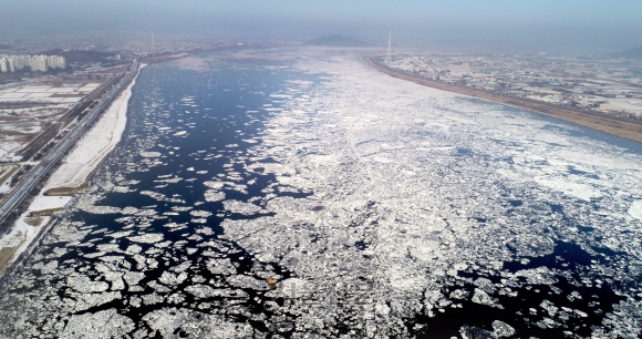 한파가 이어지는 25일 오전 경기도 김포시 일산대교 일대 한강에 유빙이 떠다니고 있다. 이날 기상청은 한강이 얼었다고 밝혔다. 이는 2000년대 들어 4번째로 일찍 한강이 언 것이다. 2022.12.25 연합뉴스