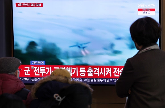 지난 26일 서울역 대합실에서 시민들이 북한 무인기 영공 침범 관련 뉴스를 시청하고 있다.  연합뉴스