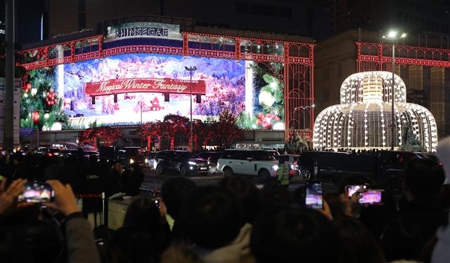 크리스마스인 25일 오후 서울 중구 명동에서 시민들이 신세계백화점 외벽의 미디어 파사드를 관람하고 있다. 2022.12.25 뉴스1