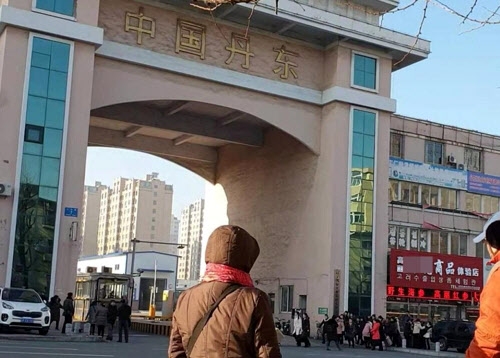 2019년 12월 북한 사람으로 보이는 노동자들이 중국 랴오닝성 단둥(丹東) 세관으로 줄지어 들어가는 모습. 연합뉴스