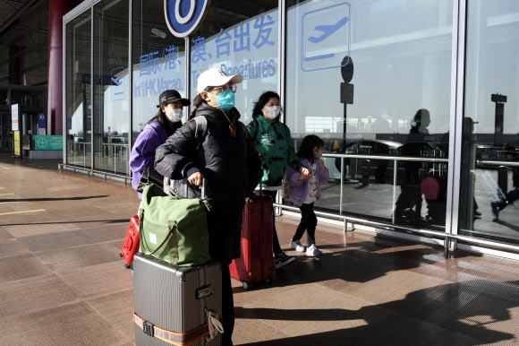 중국 베이징 서우두국제공항 터미널에서 마스크를 쓴 승객들이 걸어가고 있다. 2022.12.13 AP 연합뉴스