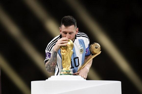 2022 카타르월드컵에서 우승한 아르헨티나 축구대표팀의 리오넬 메시가 월드컵 트로피에 입을 맞추고 있다. AP 연합뉴스