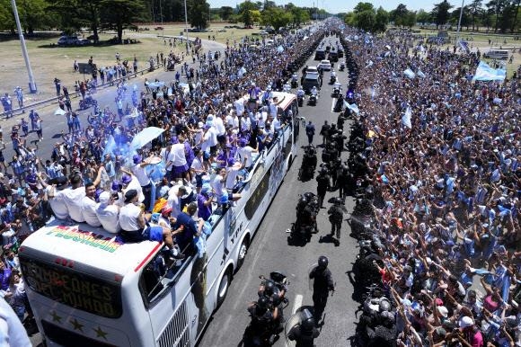 부에노스아이레스 시내에 아르헨티나 대표팀을 태운 버스가 행진하자 시민들이 환호하는 모습. 소설 ‘켄’은 종말로 치닫는 세상에서 축구에 대한 기억을 찾아 나선 주인공의 여정을 그렸다. AP 연합뉴스