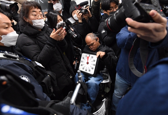 2일 오전 서울 지하철 4호선 삼각지역 승강장에서 전국장애인차별철폐연대(전장연) 회원이 5분이 표시된 시계를 들고 지하철 탑승을 시도하고 있다. 이날 전장연 회원들은 서울교통공사 측의 시위 중단과 퇴거 요구에 의해 지하철 탑승에 실패했다. 2023.1.2 홍윤기 기자