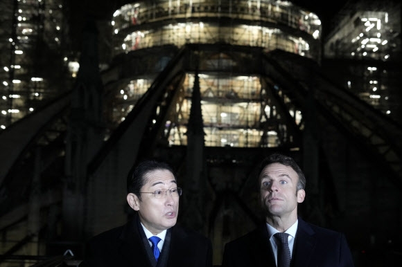 9일(현지시간) 정상회담 후 화재 피해를 입은 뒤 복원 중인 노트르담 대성당을 둘러보는 기시다 후미오 일본 총리(왼쪽)과 에마뉘엘 마크롱 프랑스 대통령. AP