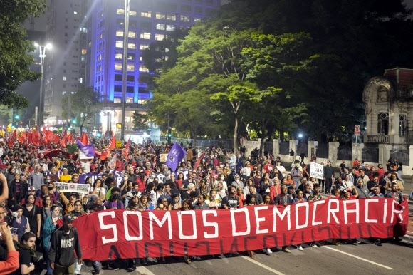 브라질의 민주 진영 시위대가 9일(현지시간) 상파울로에서 “우리가 민주주의다”라는 현수막을 들고 행진하고 있다. 전날 의회 등에 난입한 극우시위대에 대한 반발격이다. AP