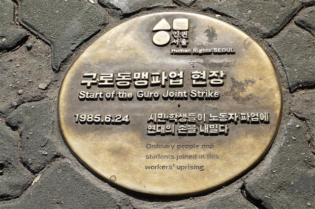 옛 가리봉오거리 보도에 부착돼 있는 1985년 6월 구로동맹파업의 현장을 기념한 바닥 동판.  서울신문 DB