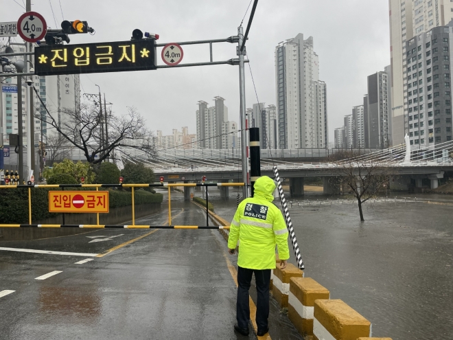 13일 오전 많은 비가 내리면서 경찰이 부산 동래구 온천천 옆 도로의 출입을 통제하고 있다. 부산경찰청 제공