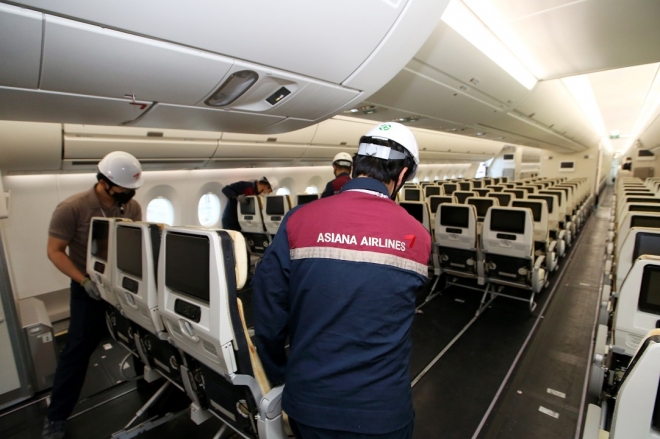 아시아나항공 직원들이 코로나19 당시 화물기로 개조된 여객기에 다시 좌석을 장착하면서 여객기로 복원하는 모습. 아시아나항공 제공