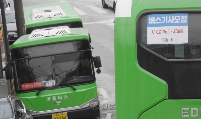 서울과 경기도 마을버스 기사들이 낮은 급여로 인해 대거 퇴사하면서 시민의 발인 마을버스가 줄줄이 멈춰 서고 있다. 17일 서울 종로구에 있는 한 마을버스 차고지에 주차된 버스에 운전기사 구인 광고가 붙어 있다. 홍윤기 기자