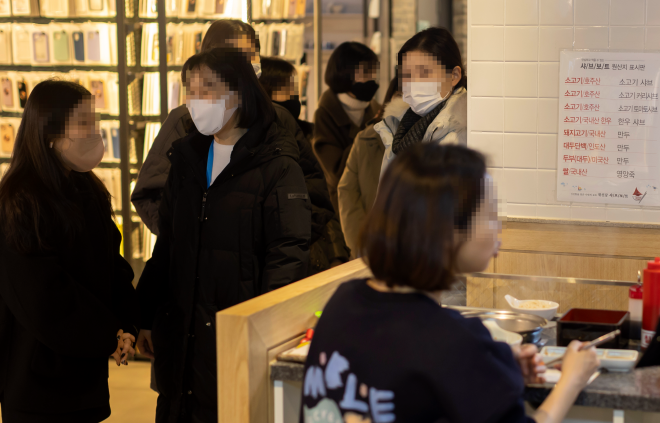 정부 차원의 실내마스크 착용 의무 해제 논의가 시작된 17일 점심시간 서울의 한 식당가에서 시민들이 마스크를 쓴 채 입장을 기다리고 있다. 연합뉴스