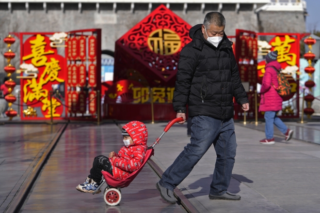 17일 중국 베이징의 관광 명소 첸먼 거리에서 한 남성이 유모차를 끌고 있다. 세계 최대 인구 대국인 중국은 출생률 급감에 따른 인구 감소에 직면해 있다. 유엔은 올해 인도 인구가 중국을 추월할 것으로 전망했다. 베이징 AP 연합뉴스