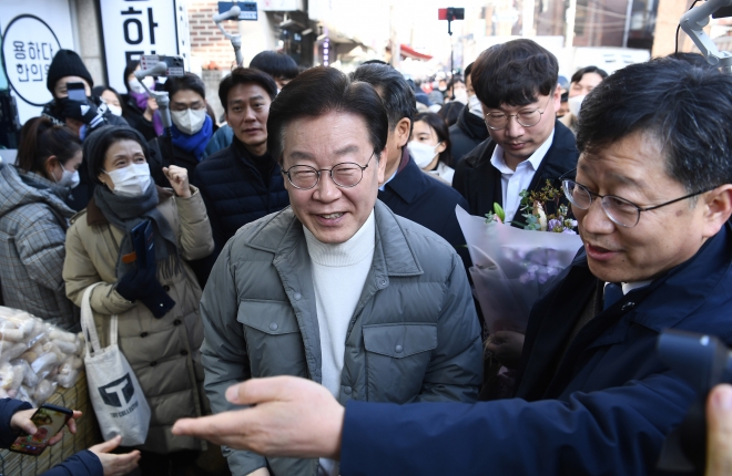 이재명(가운데) 더불어민주당 대표가 설 연휴를 앞둔 18일 서울 마포구 망원시장을 방문해 시민들과 인사하고 있다. 뉴시스