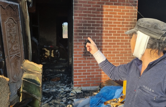화재 현장에서 만난 손수호씨가 자신이 진입한 화재 현장 뒷문을 가리키며 당시 상황을 설명하고 있다.