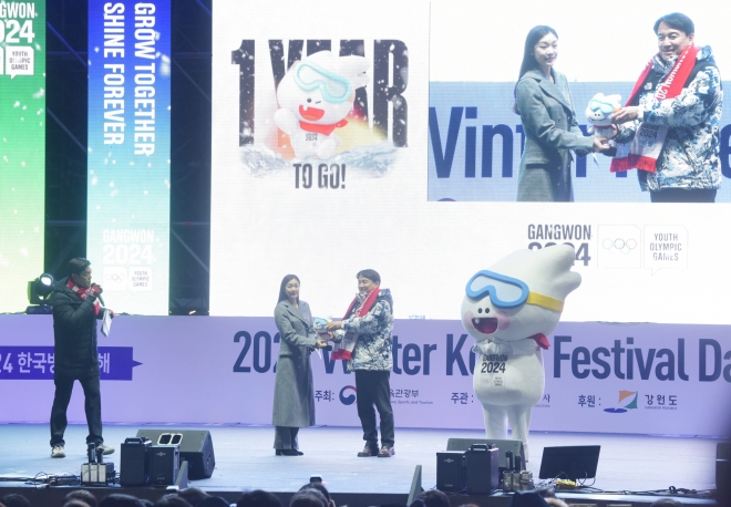 김진태 (오른쪽 두 번째) 강원도지사가 강원동계청소년올림픽 홍보대사인 ‘피겨 퀸’ 김연아에게 대회 마스코트 인형을 선물하고 있다. 오른쪽 끝은 대회 상징물인 ‘뭉초’.