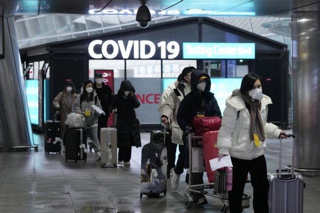 인천공항에 도착한 중국발 항공기 승객들이 지난 14일 코로나19 선별진료소 앞을 지나고 있다. 인천 AP 연합뉴스