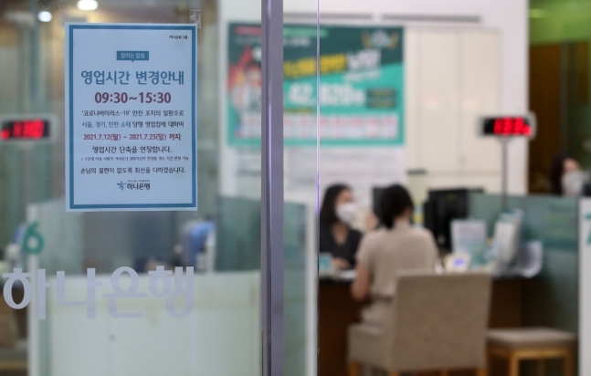 오는 30일부터 실내마스크 의무 착용이 해제되면서 은행 영업시간 정상화에 대한 논의가 진행된다. 사진은 서울 중구 하나은행에 영업시간 단축 안내문이 붙어 있는 모습. 뉴스1
