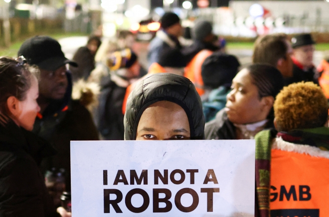 영국 코번트리 아마존 물류창고 직원이 25일(현지시간) 파업에 참여하며 ‘나는 로봇이 아니다’라고 적힌 피켓을 들고 있다. 코번트리 로이터 연합뉴스