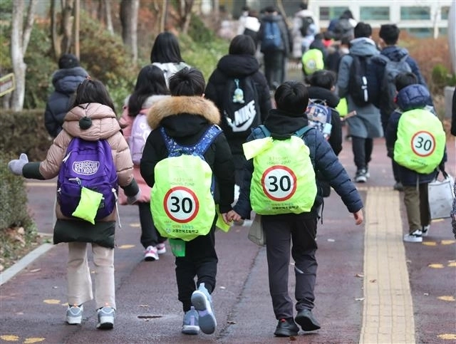 서울 청담동 연북초등학교 앞 어린이 보호구역(스쿨존)에서 음주운전 뺑소니 차량에 치여 한 초등학생이 숨진 가운데 이 학교 학생들이 13일 스쿨존 내 최고 시속 30㎞ 제한을 요구하는 가방을 메고 등교하고 있다. 뉴스1
