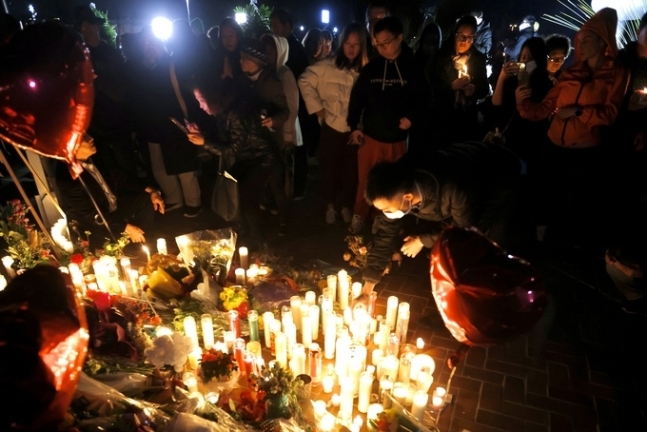 23일(현지시간) 미국 캘리포니아주 로스앤젤레스 인근 소도시인 몬터레이 파크 시청 앞에서 시민들이 이틀 전 발생한 총격사건 희생자들을 기리며 촛불을 켜고 있다. 신화 연합뉴스