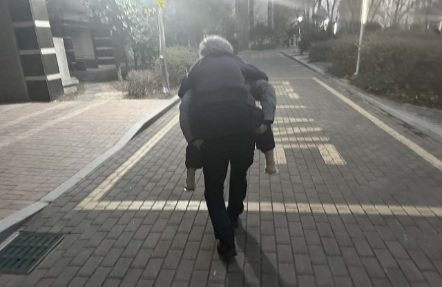 부산 경찰이 지난 26일 공식 페이스북에 길 잃은 할머니를 업고 이동하는 한 경찰관의 모습을 공개했다. 부산경찰 페이스북 캡처