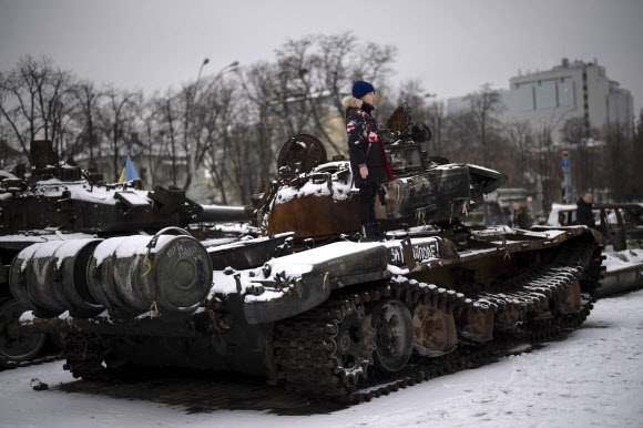 지난달 31일(현지시간) 한 소년이 우크라이나 키이우에서 파괴된 러시아 탱크 위에 서 있다.  AP