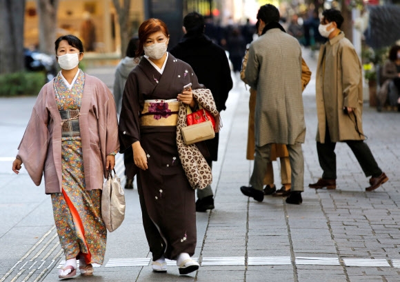 일본의 코로나19 하루 신규 확진자 수가 13일 이틀 연속 역대 최다(1661명, 1695명)를 기록한 가운데 수도 도쿄의 한 거리에서 기모노를 입은 여성들이 마스크를 쓴 채 걸어가고 있다. 2020.11.13  로이터 연합뉴스