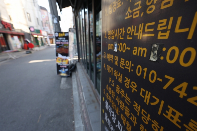 14일 오후 서울 건국대학교 인근 술집에 코로나19 확산 이전에 붙여놓은 듯한 영업시간 안내문이 내걸려 있다. 연합뉴스