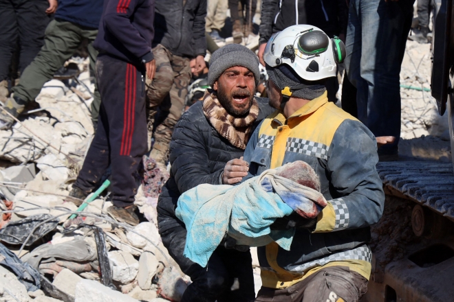 튀르키예와 시리아를 강타한 치명적인 지진 이틀 후인 8일(현지시간) 튀르키예의 국경에 있는 시리아 반군이 장악하고 있는 노리흐 서부 이들리브 주 하림 마을에서 한 남성이 잔해에서 아기의 시신을 꺼내자 반응하고 있다. AFP 연합뉴스