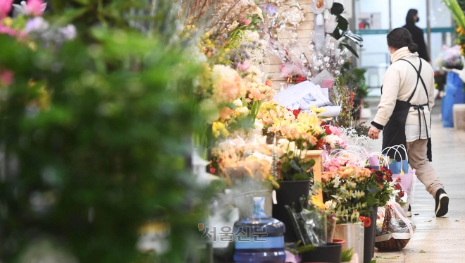 14일 서울의 한 꽃시장의 상인이 꽃을 정리하기 위해 이동하고 있다. 방역당국의 코로나19 규제 완화로 각 학교의 졸업식이 정상적으로 열리면서 꽃 수요가 증가했지만, 꽃다발이 최소 5~6만원대 판매가가 형성되는 등 소비자들의 부담이 가중되고 있다.홍윤기 기자