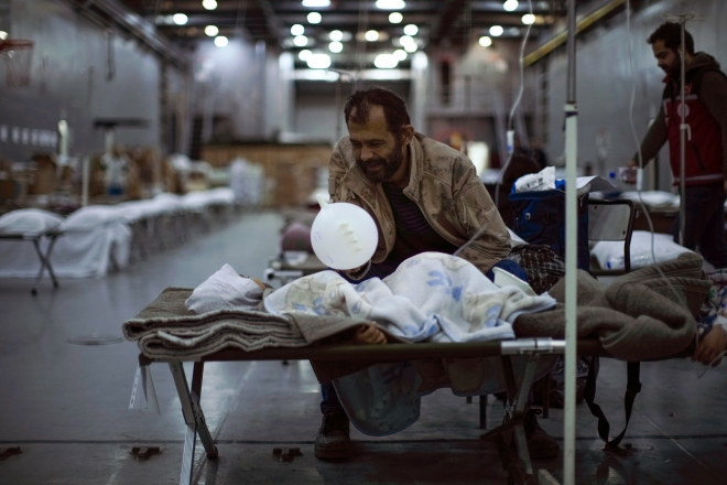 Hope Found in Wreckage A man waves a balloon to a child lying in bed and smiles at a makeshift hospital on a warship docked in the port near Iskenderun, southern Turkey.  Iskenderun AP News