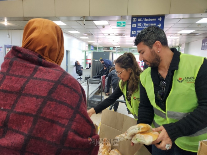 하칸이 아다나 공항에서 대기 중인 이재민들에게 샌드위치를 나눠주고 있다. 아다나 곽소영 기자