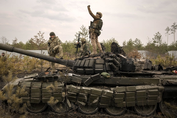 우크라이나 병사가 지난달 31일(현지시간) 키이우(키예프) 외곽에서 파괴된 러시아군 탱크 위에 올라 셀카를 찍고 있다. AP 연합뉴스