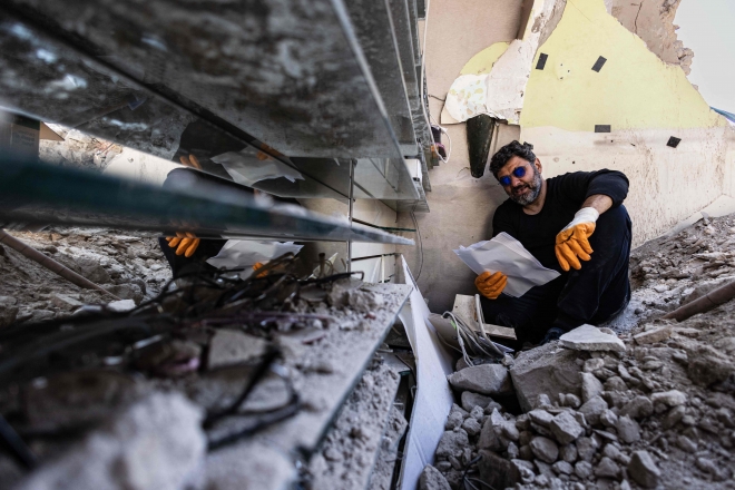 지난 6일 대지진이 일어난 튀르키예 하타이주 안타키아 지역의 무너져 내린 안경점에서 18일(현지시간) 안경사 쥐네이트 에로글루(45)가 렌즈 조각들을 수습하고 있다. 튀르키예 당국은 4만 6000명 이상의 목숨을 앗아간 지진이 발생한 지 2주가 지나면서 수색 작업을 마무리한다고 밝혔다. 안타키아 AFP 연합뉴스