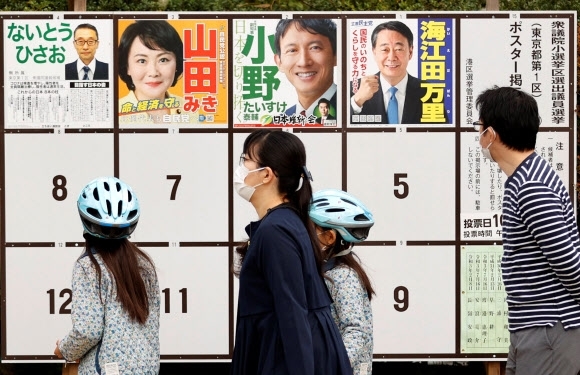 일본 중의원(하원) 선거 투표일인 31일 수도 도쿄의 투표소 밖에서 한 유권자가 선거 벽보를 살펴보고 있다. AP 연합뉴스