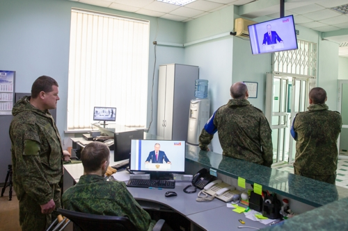 우크라이나 돈바스 지역 휴전을 감시하는 ‘휴전·전선 안정화 문제 감시 및 조정 공동센터’(JCCC) 직원들이 블라디미르 푸틴 대통령의 연설을 지켜보고 있다. 루한스크 타스 연합뉴스