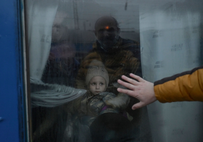 (FILES) In this file photo taken on March 07, 2022 a father puts his hand on the window as he says goodbye to his daughter in front of an evacuation train at the central train station in Odessa. (Photo by BULENT KILIC / AFP)