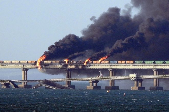 In this file photo taken on October 08, 2022 Black smoke billows from a fire on the Kerch bridge that links Crimea to Russia, after a truck exploded, near Kerch. - Moscow announced on October 8, 2022 that a truck exploded igniting a huge fire and damaging the key Kerch bridge -- built as Russia‘s sole land link with annexed Crimea -- and vowed to find the perpetrators, without immediately blaming Ukraine. (Photo by AFP)