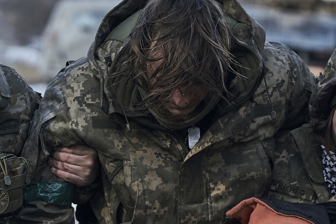 Military medics help a soldier wounded in a battle to get into an evacuation vehicle near Bakhmut, Donetsk region, Ukraine, Wednesday, Feb. 22, 2023. (AP)