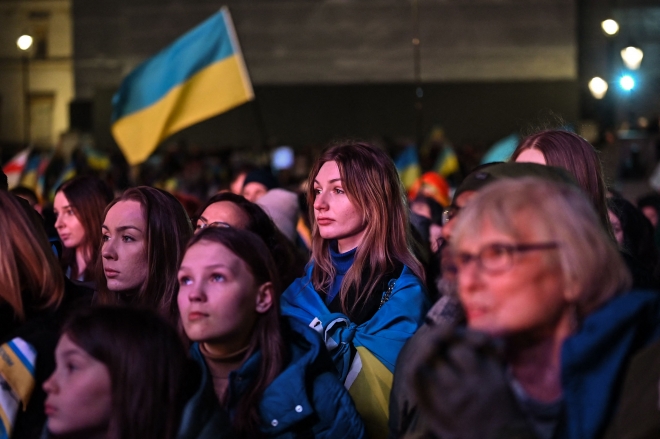 러시아의 우크라이나 침공 1년을 앞둔 23일(현지시간) 영국 런던 트라팔가 광장에 모인 시민들이 우크라이나 국기를 흔들고, 우크라이나 국기를 몸에 두르고 연대의 뜻을 표하고 있다. 런던 AFP 연합뉴스