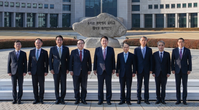 윤석열 대통령이 24일 국가정보원을 찾아 2023년도 업무계획을 보고받기에 앞서 국정원 원훈석 앞에서 간부들과 기념촬영을 하고 있다. (연합뉴스)