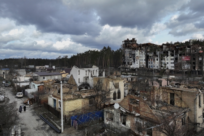 26일(현지시간) 우크라이나 이르핀에서 주민들이 파괴된 건물 사이를 걸으며 지나고 있다. 러시아의 침공이 1년을 넘어섰지만 이르핀을 비롯한 키이우 외곽 도시들은 아직 폐허로 남아 있다. 뉴시스