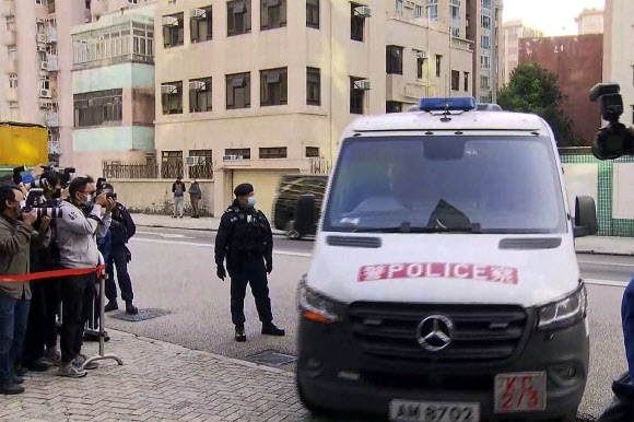 홍콩 모델 겸 인플루언서 애비 초이 피살 사건을 취재하는 기자들이 27일 코울룬 시티 법원 건물 앞에 도착한 경찰 밴승합차를 담고 있다. AP는 피해자의 가족이 타고 있는 것으로 추정했다. TVB 홍콩 동영상 캡처 AP 연합뉴스