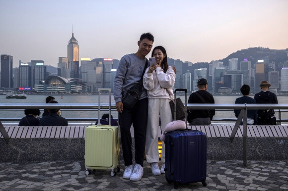 홍콩이 관광 활성화 정책을 개시한 지난 1일 해외 여행자 커플이 홍콩의 상징인 마천루를 배경으로 셀카를 찍고 있다. 홍콩 AP 연합뉴스