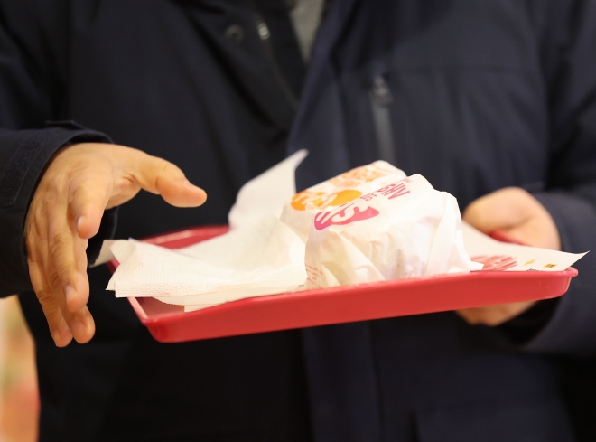 서울의 한 롯데리아 매장에서 소비자가 햄버거를 들고 있다. 2023.1.26 연합뉴스