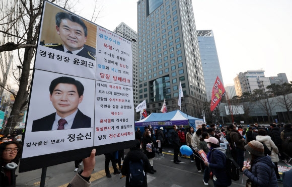 4일 오후 서울 중구 숭례문 앞 대로에서 촛불행동 주최로 열린 29차 촛불대행진에서 한 참가자가 아들의 학교폭력 전력이 드러나 경찰청 국가수사본부장에서 낙마한 정순신 변호사와 그를 추천한 윤희근 경찰청장을 규탄하는 손팻말을 들고 있다. 2023.3.4 연합뉴스