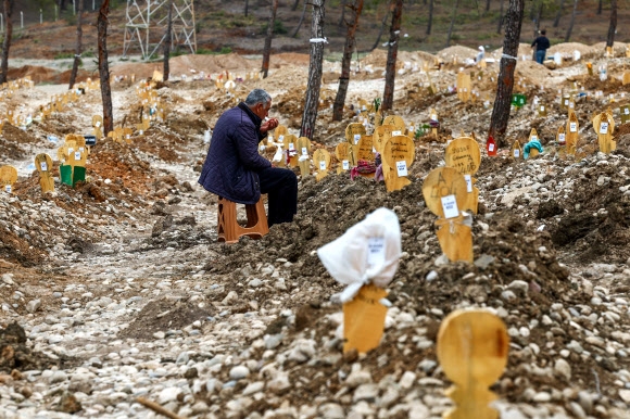 튀르키예와 시리아에서 5만 1000명 이상의 목숨을 앗아간 연쇄 강진이 발생 한 달을 넘긴 가운데 튀르키예 카라만마라슈에서 한 주민이 지진으로 목숨을 잃은 친척들의 무덤에서 애도하고 있다. 2023.3.5 EPA 연합뉴스